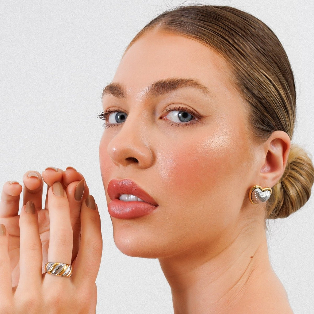 Heart-shaped stud earrings with a mix of gold and silver plating.